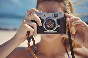 Single-Frau macht am Strand Foto von ihrem Liebsten