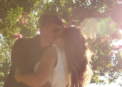 Frau und Mann küssen sich unter blühendem Baum
